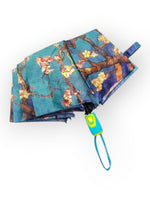 Umbrelă compactă, pliată, cu husă de transport și imprimeu artistic „Migdal Înflorit”.