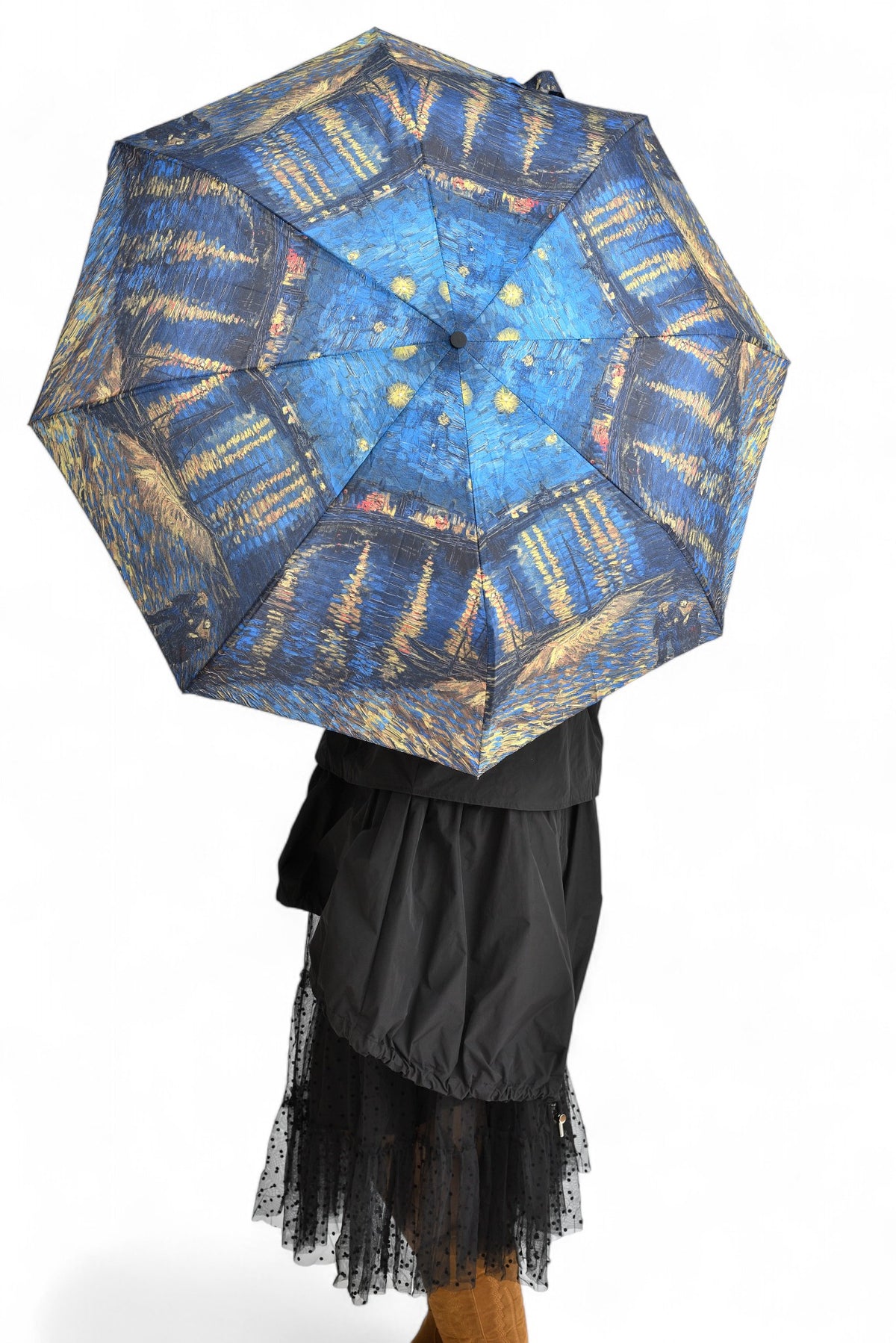 Femeie ținând o umbrelă cu design artistic „Noaptea Înstelată” de Van Gogh, perfectă pentru zile ploioase.