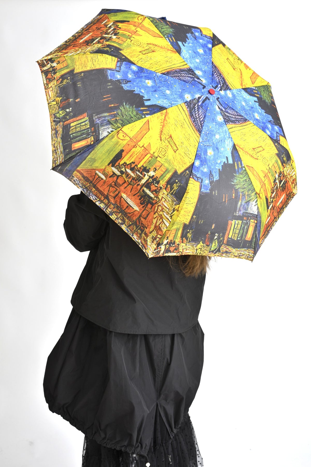 Umbrelă deschisă cu imprimeu inspirat din pictura „Café Terrace at Night” a lui Vincent van Gogh, în nuanțe de albastru și galben intens.