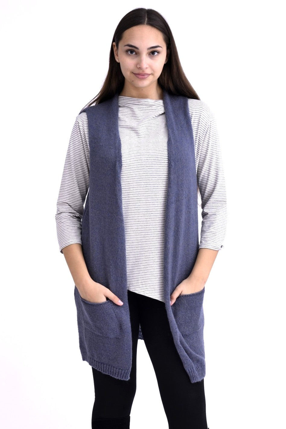 Vedere din spate a unei veste lungi tricotate bleumarin, cu textură moale și lejeră, purtată peste o bluză alb-gri în dungi.