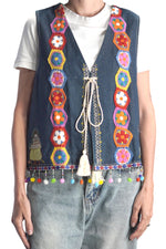 Detaliu față vesta jeans cu motive florale croșetate și șnur cu ciucuri.
