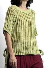 Detaliu tricot aerisit la vestă tip plasă, cu model deschis și cădere lejeră.