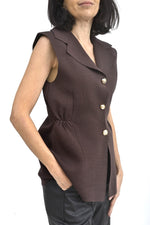 Vestă din tricot elastic burgundy, croială cambrată, fotografie semiprofil ce evidențiază linia taliei.