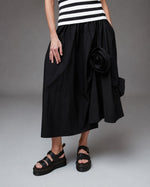 All Above Boutique black cotton asymmetric midi skirt with applied floral detail and elastic waist.