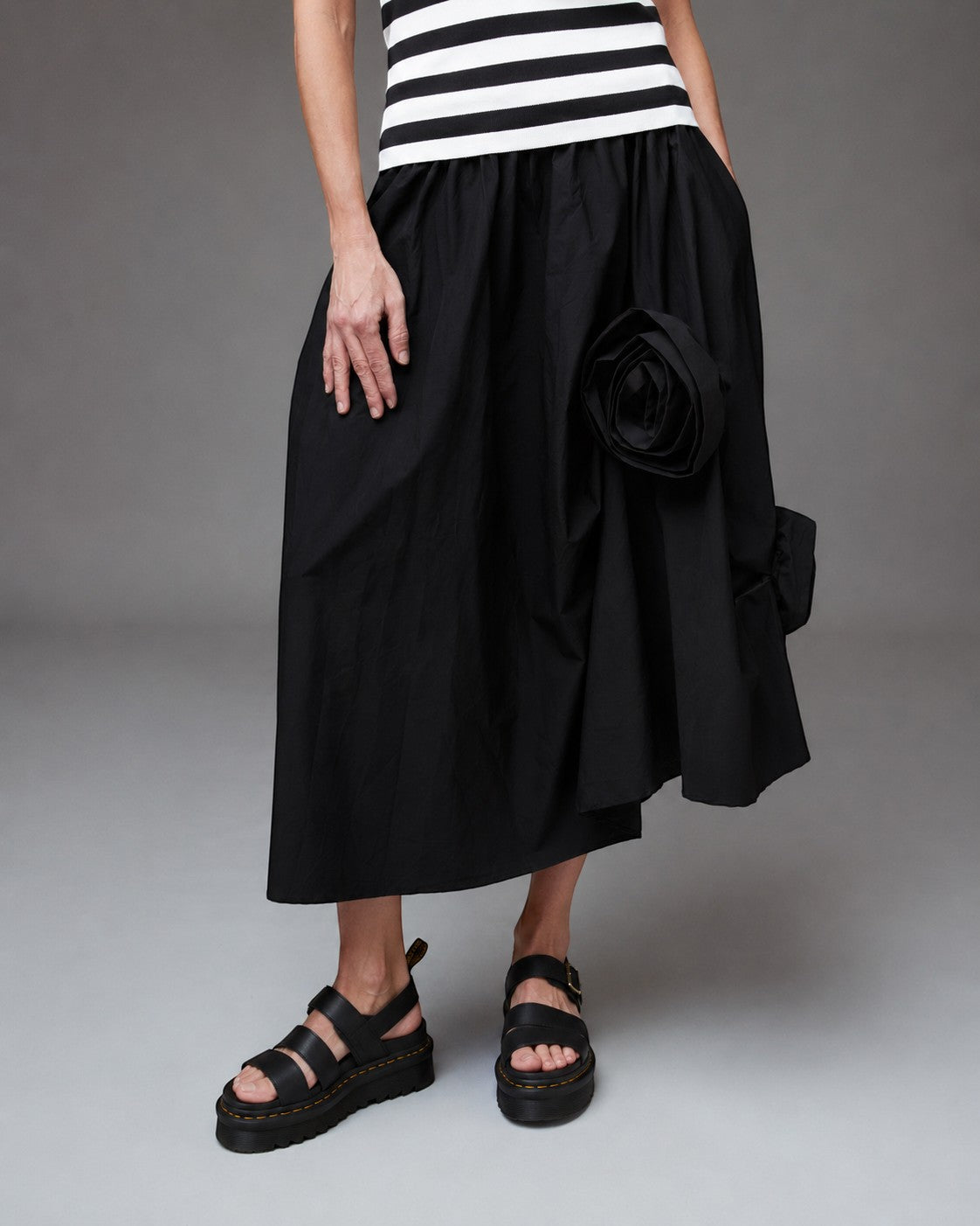 All Above Boutique black cotton asymmetric midi skirt with applied floral detail and elastic waist.