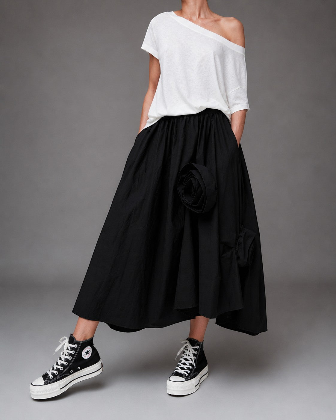 All Above Boutique black cotton asymmetric midi skirt with applied floral details and elastic waist.