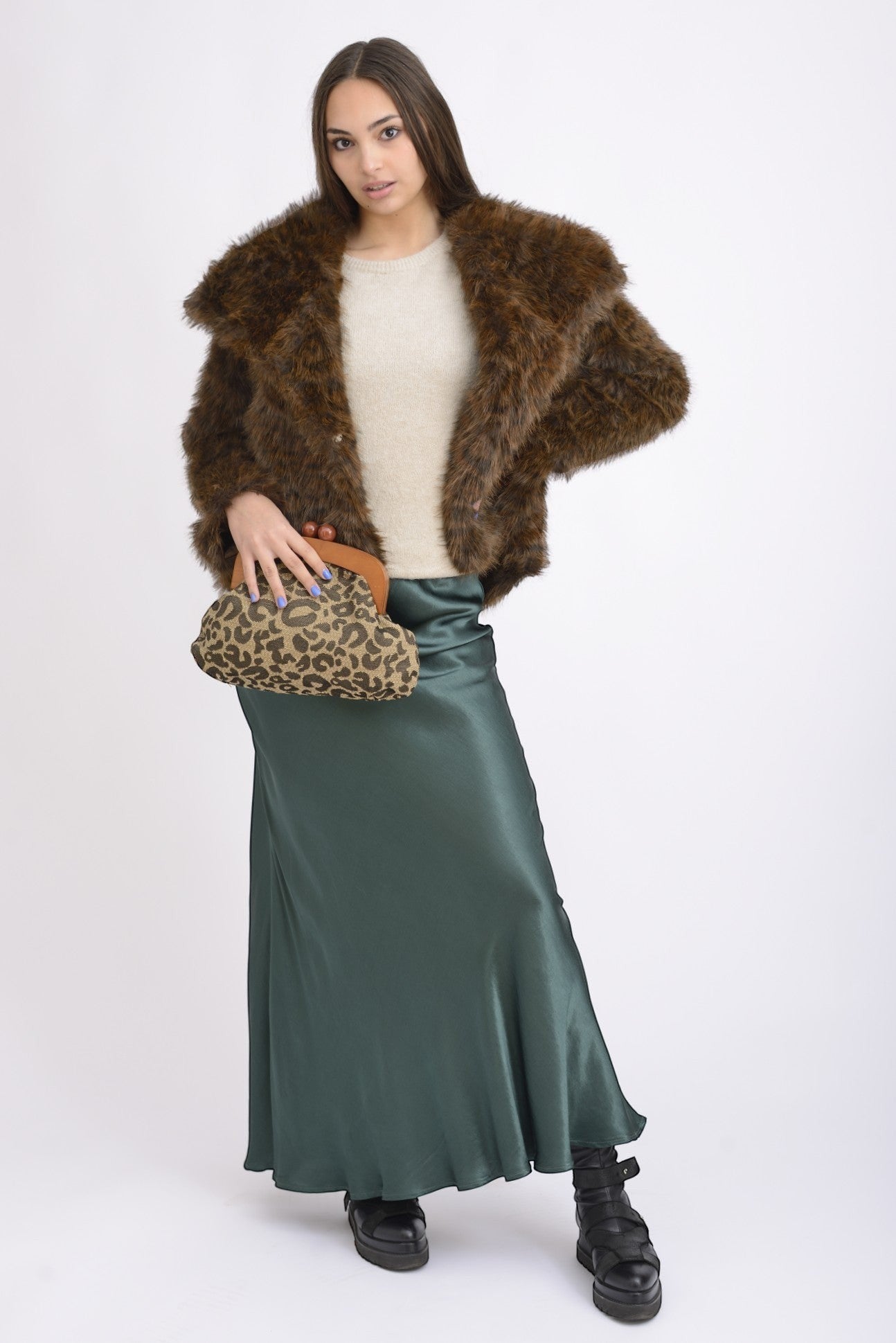 All Above Boutique animal print clutch with wooden frame and gold chain, worn by a model in a faux fur coat and satin skirt.