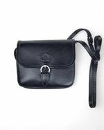 All Above Boutique black leather crossbody satchel with buckle closure and adjustable strap.