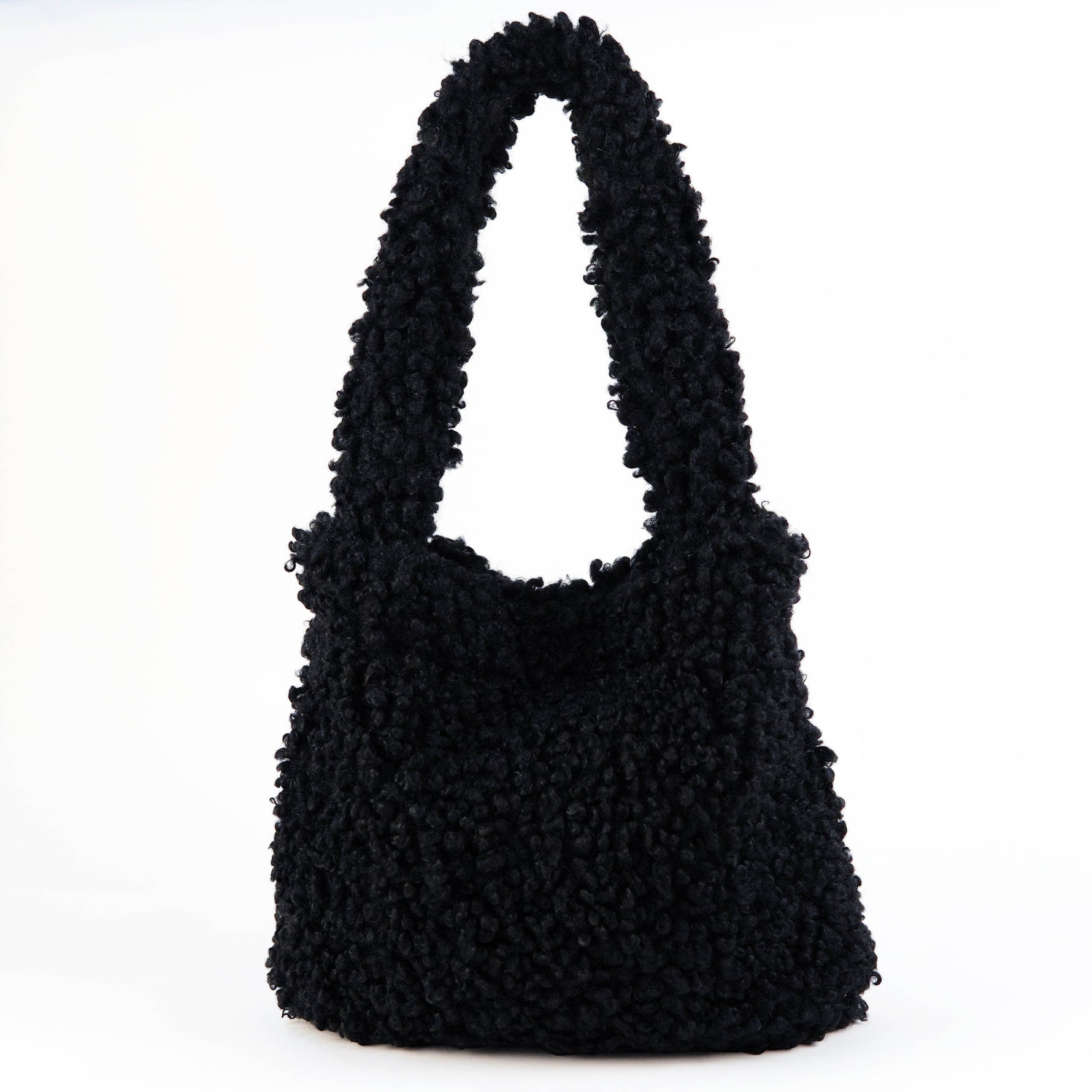 All Above Boutique black teddy bag with fluffy texture and double handles. Magnetic snap closure for easy access.