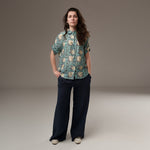 All Above Boutique women's light blue rayon floral print short sleeve shirt with asymmetric hem and navy wide-leg pants.