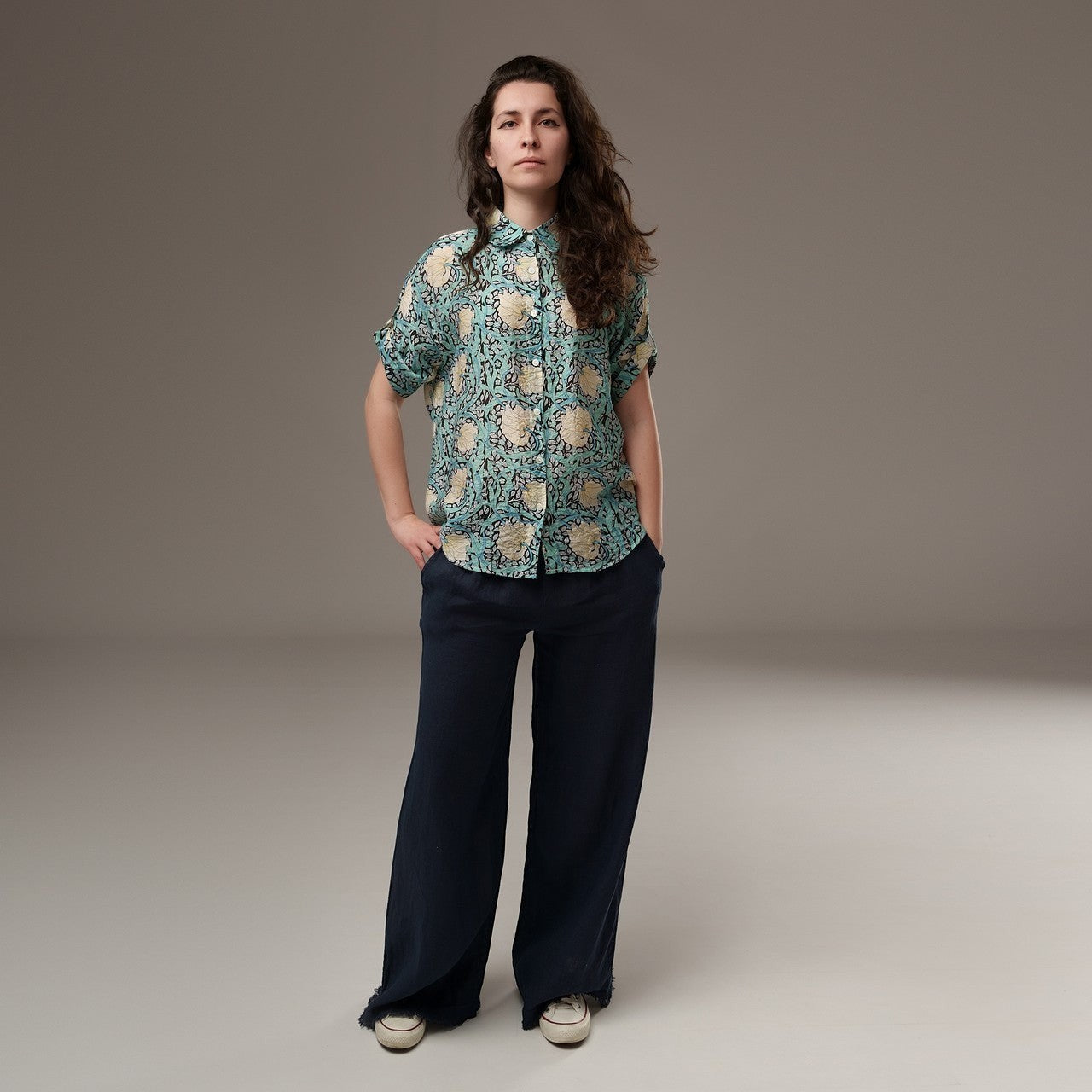 All Above Boutique women's light blue rayon floral print short sleeve shirt with asymmetric hem and navy wide-leg pants.