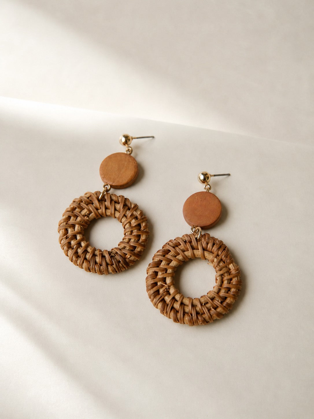 All Above Boutique boho style braided wood hoop earrings with wooden bead accent. Natural brown.