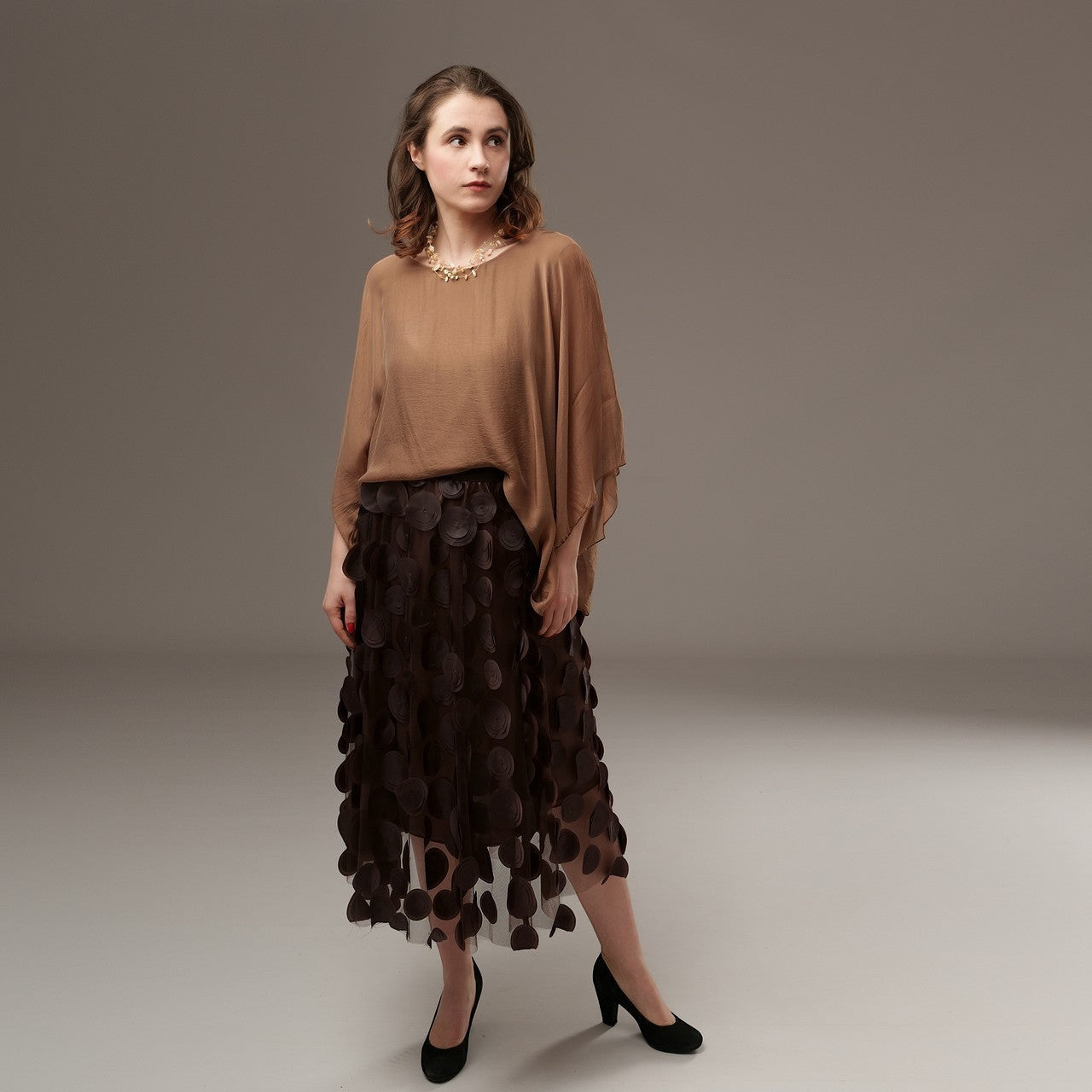 All Above Boutique brown midi tulle skirt with applied petals and elastic waist, worn by a model.