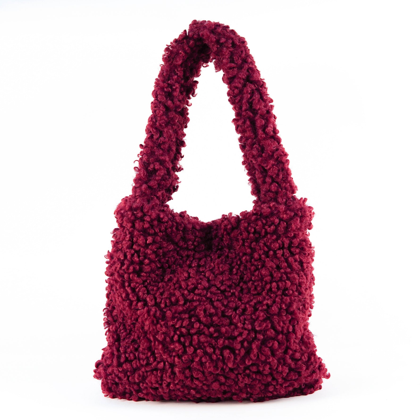 All Above Boutique burgundy teddy bag with double handles and magnetic snap closure. Soft, fluffy texture, ideal for casual wear.