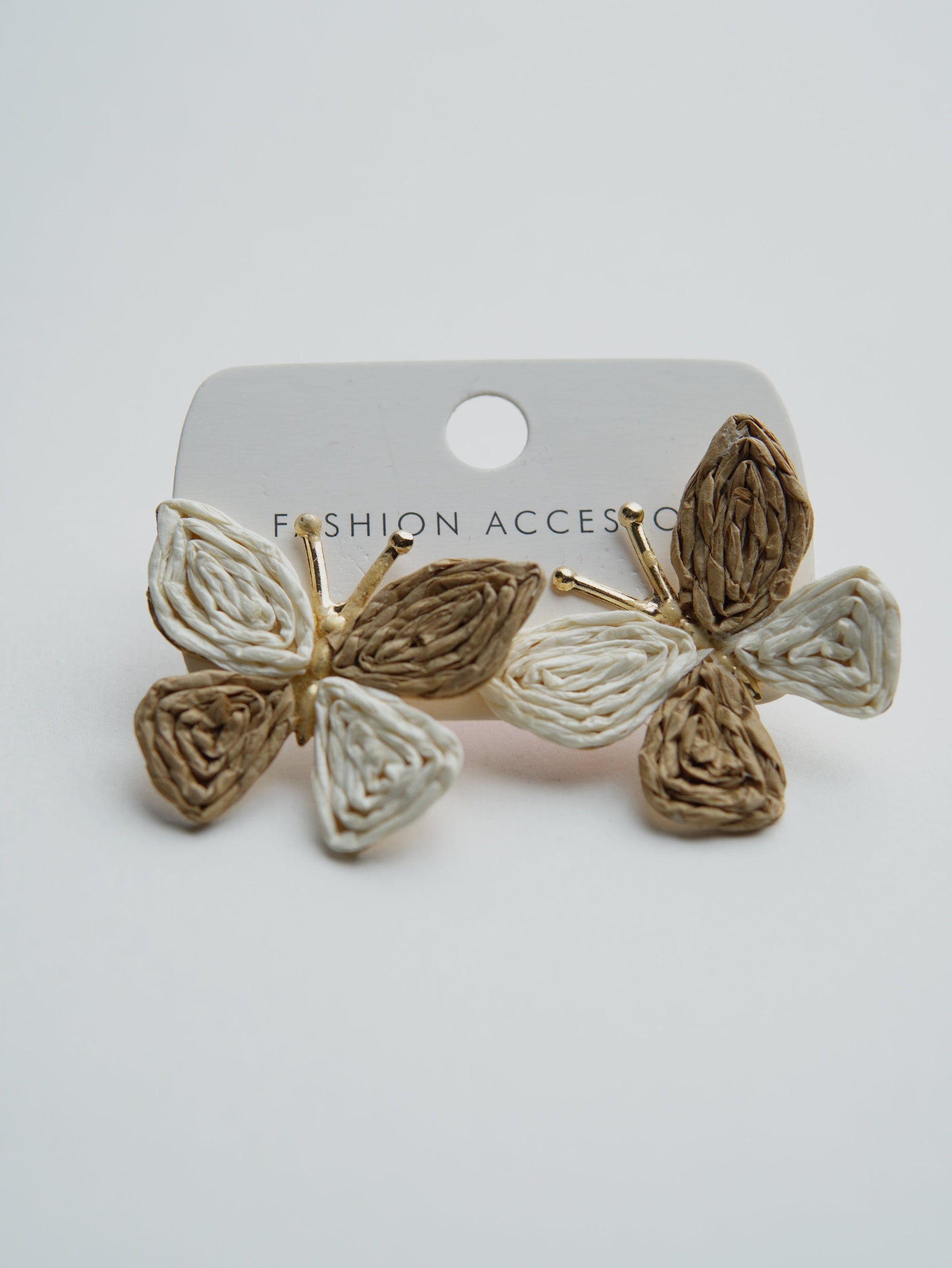 All Above Boutique butterfly earrings made of woven straw in beige and white, perfect for a boho summer look.
