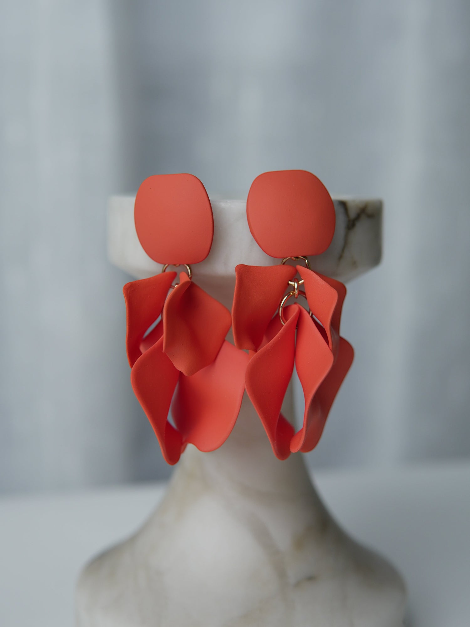 All Above Boutique coral matte metal petal drop earrings with geometric base. Elegant, dynamic, and lightweight statement earrings.