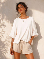All Above Boutique cream cotton 3/4 sleeve relaxed fit blouse with ruffled cuffs and crew neck.
