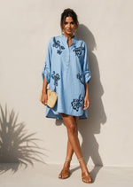 All Above Boutique light blue denim shirt dress with dark blue floral embroidery, mandarin collar, and rolled sleeves.