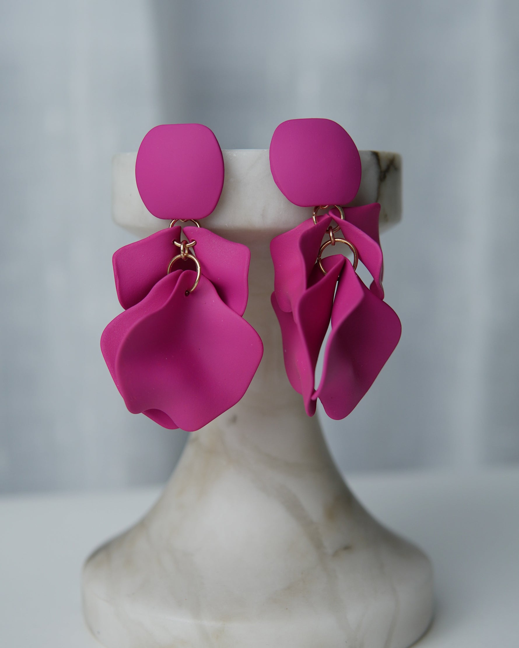 All Above Boutique matte fuchsia petal drop earrings with geometric base. Elegant, dynamic, and lightweight statement jewelry.