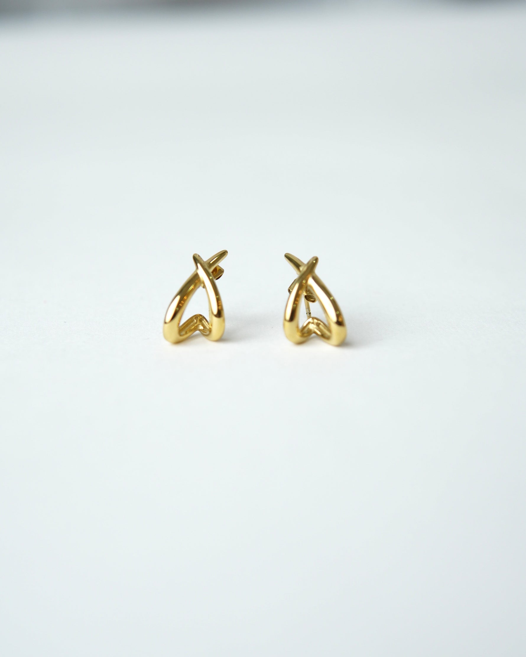 All Above Boutique gold organic asymmetrical hoop earrings with a polished finish.
