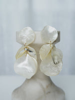 All Above Boutique statement earrings with layered mother-of-pearl petals in iridescent white, dangling design.