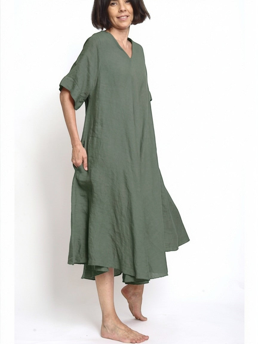 All Above Boutique olive green 100% linen V-neck midi dress with short sleeves and side pockets, worn by a woman.