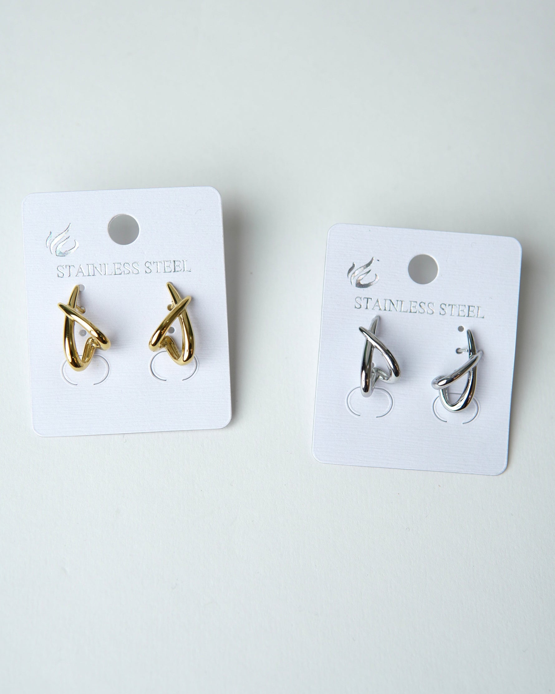 All Above Boutique gold and silver organic asymmetrical stainless steel earrings with a glossy finish.