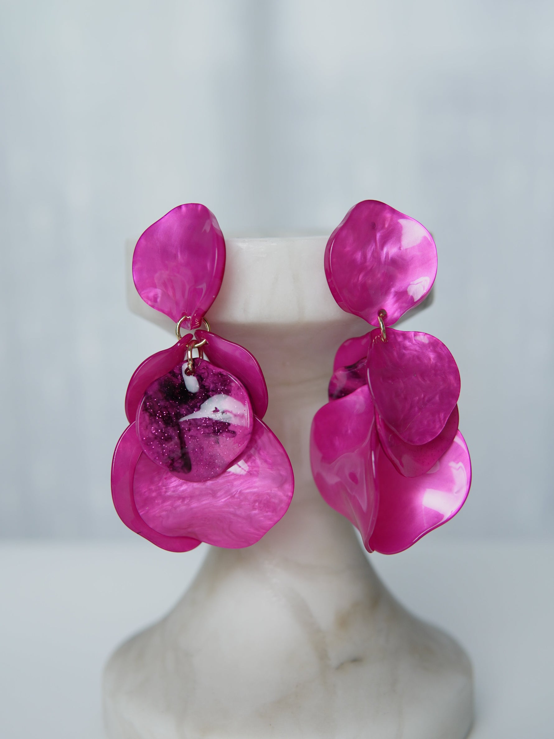 All Above Boutique statement earrings with layered pink petals and iridescent marbled effect, featuring glitter accents.