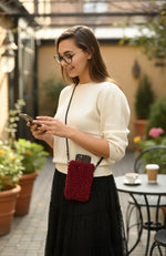 All Above Boutique red bouclé phone bag with adjustable strap, worn crossbody by a model.