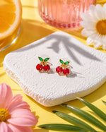 All Above Boutique playful red cherry stud earrings with green leaf detail, perfect for summer.