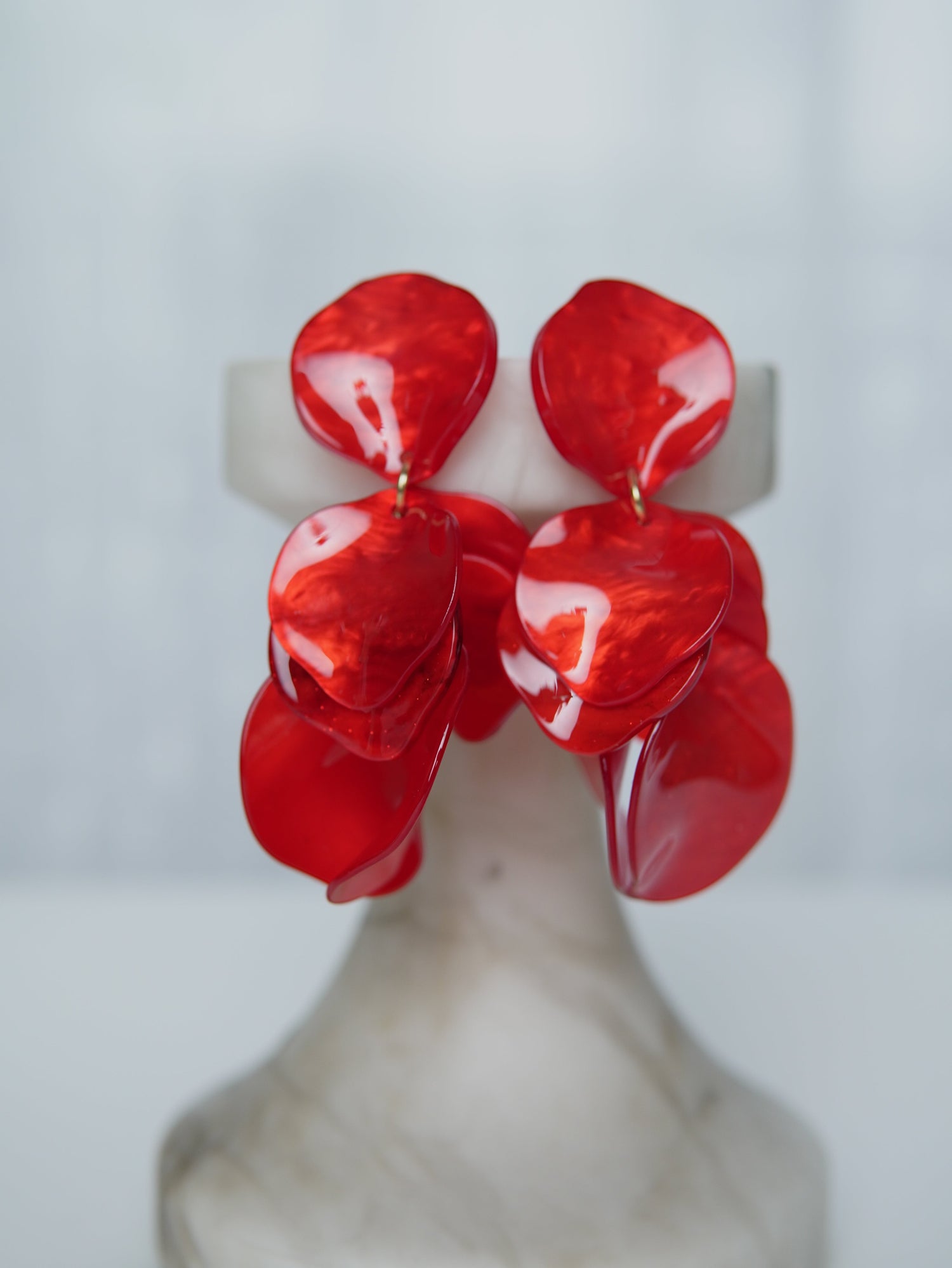 All Above Boutique red statement earrings with layered, iridescent petal shapes. Lightweight and versatile.