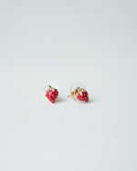 All Above Boutique small red strawberry stud earrings with gold accents and clear backing.