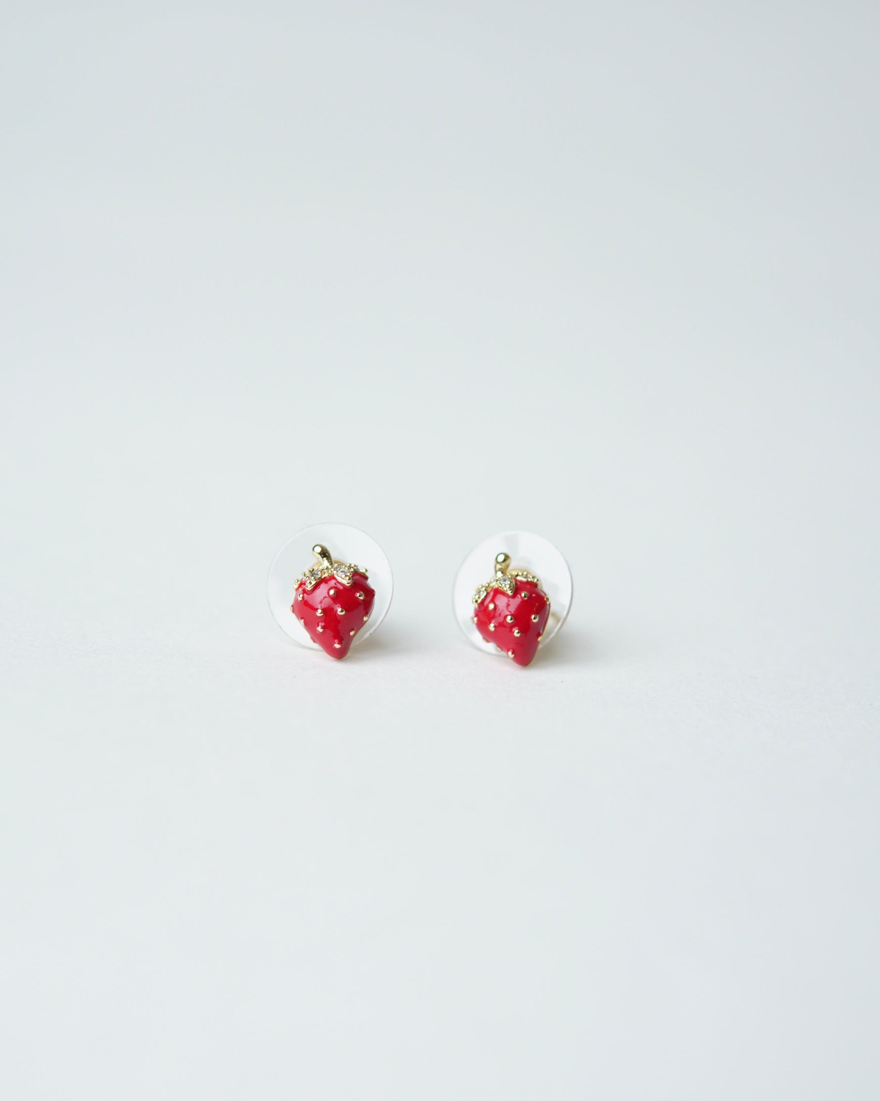 All Above Boutique small red strawberry stud earrings with gold accents and clear backing, perfect for a playful, feminine look.