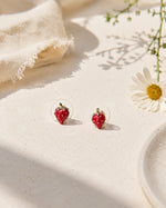 All Above Boutique small red strawberry stud earrings with gold stems and clear backing, featuring a glossy finish.