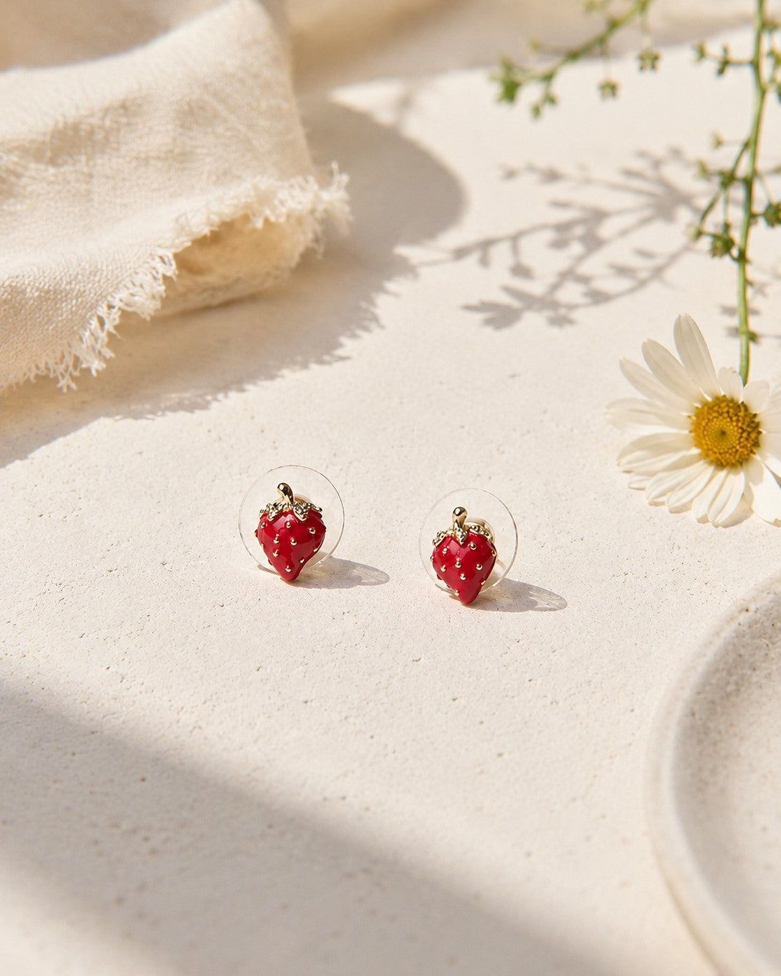 All Above Boutique small red strawberry stud earrings with gold stems and clear backing, featuring a glossy finish.