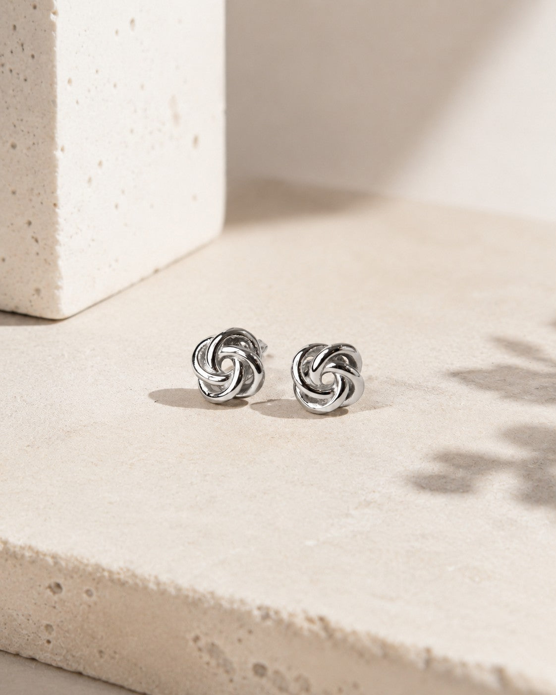 All Above Boutique silver knot stud earrings with a floral-inspired, intertwined design. Elegant and versatile.