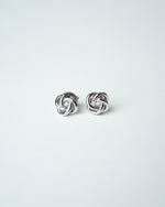 All Above Boutique silver knot stud earrings with a polished metallic finish, featuring a floral-inspired design.