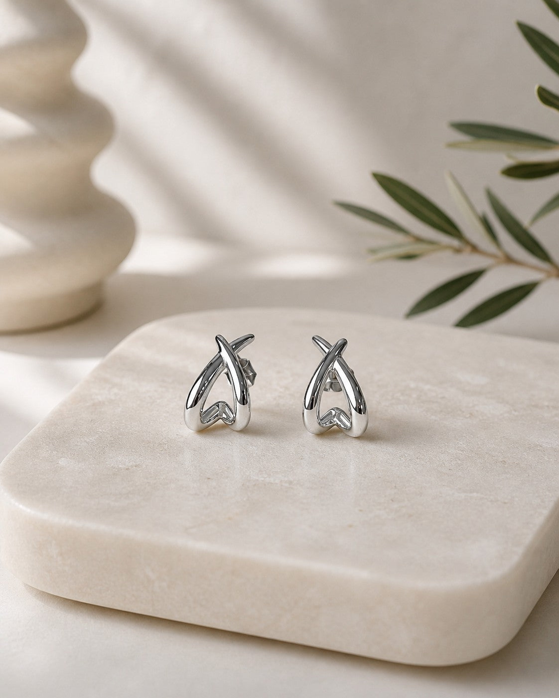 All Above Boutique silver organic asymmetrical stud earrings with a polished finish.