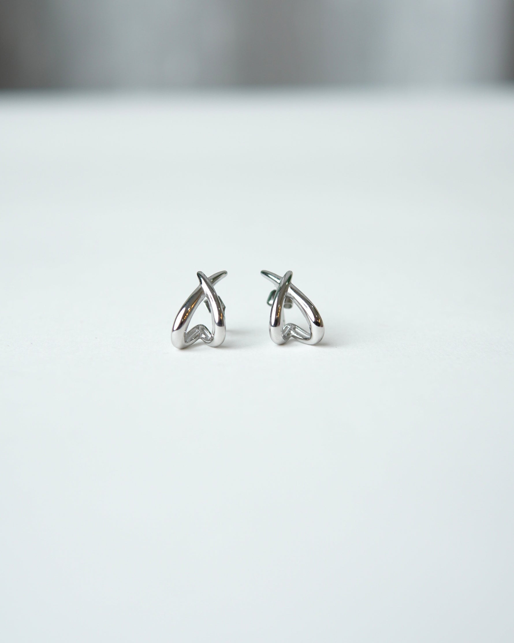 All Above Boutique silver organic asymmetrical stud earrings with a polished finish.