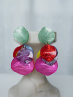 All Above Boutique statement earrings with layered, iridescent petals in pink, red, yellow, blue, and green.