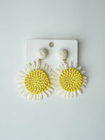 All Above Boutique daisy flower straw earrings with yellow centers and white petals, perfect for summer.