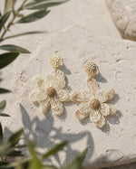 All Above Boutique natural straw flower dangle earrings with gold textured studs.