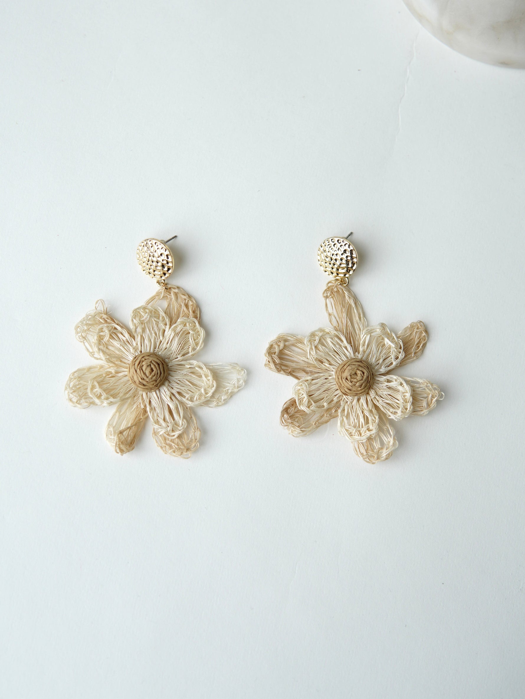 All Above Boutique natural straw flower dangle earrings with gold textured studs.