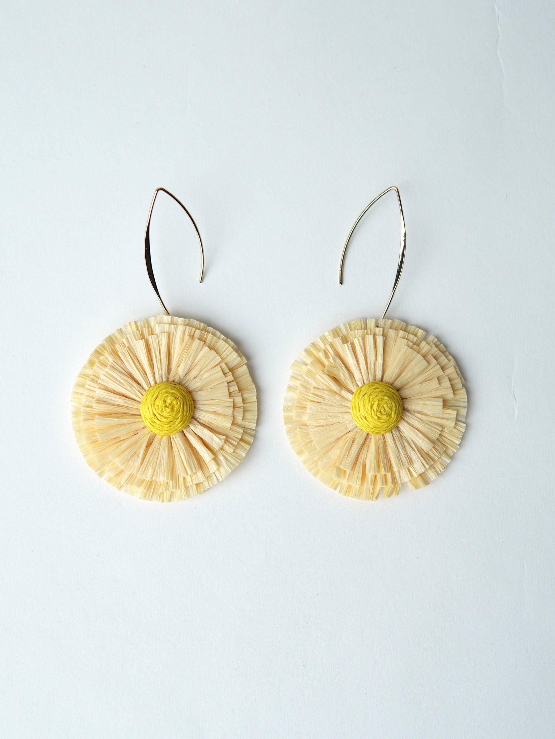 All Above Boutique natural straw flower earrings with yellow center and silver hooks. Boho statement jewelry.