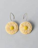 All Above Boutique natural straw flower earrings with yellow center and silver hooks. Boho statement jewelry.