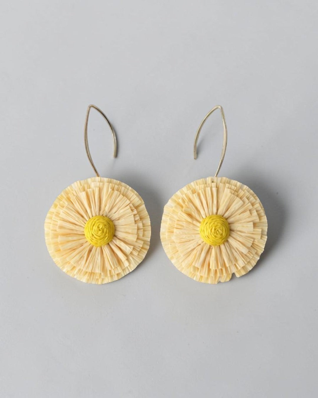 All Above Boutique natural straw flower earrings with yellow center and silver hooks. Boho statement jewelry.