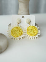 All Above Boutique daisy flower straw earrings with yellow centers and white petals, natural summer style.