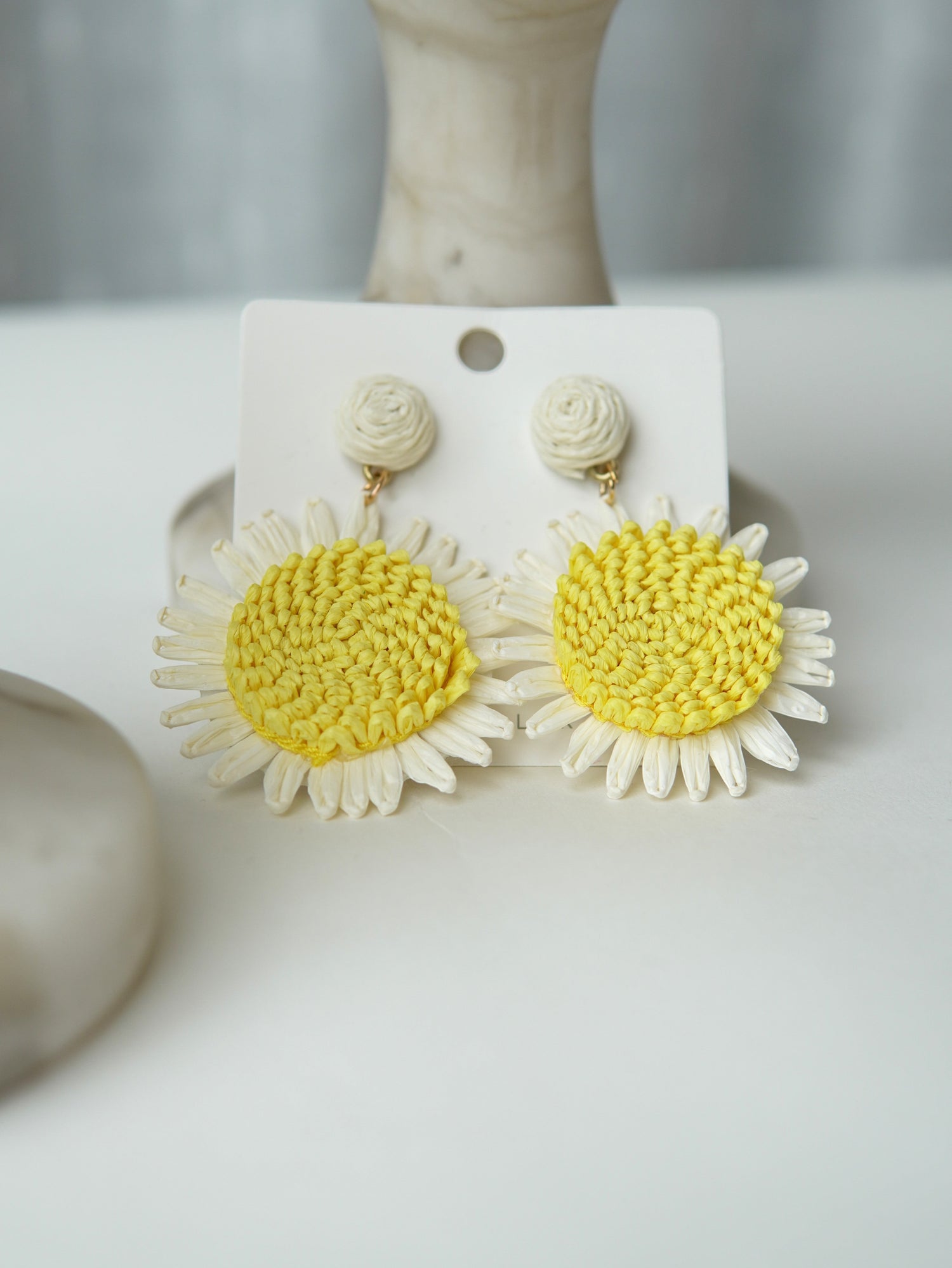 All Above Boutique daisy flower straw earrings with yellow centers and white petals, natural summer style.