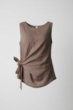 All Above Boutique taupe linen sleeveless tie-waist top. Relaxed fit, breathable, and perfect for warm weather.