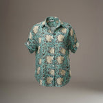 All Above Boutique light teal rayon shirt with a cream floral print, short sleeves, and an asymmetric hem.